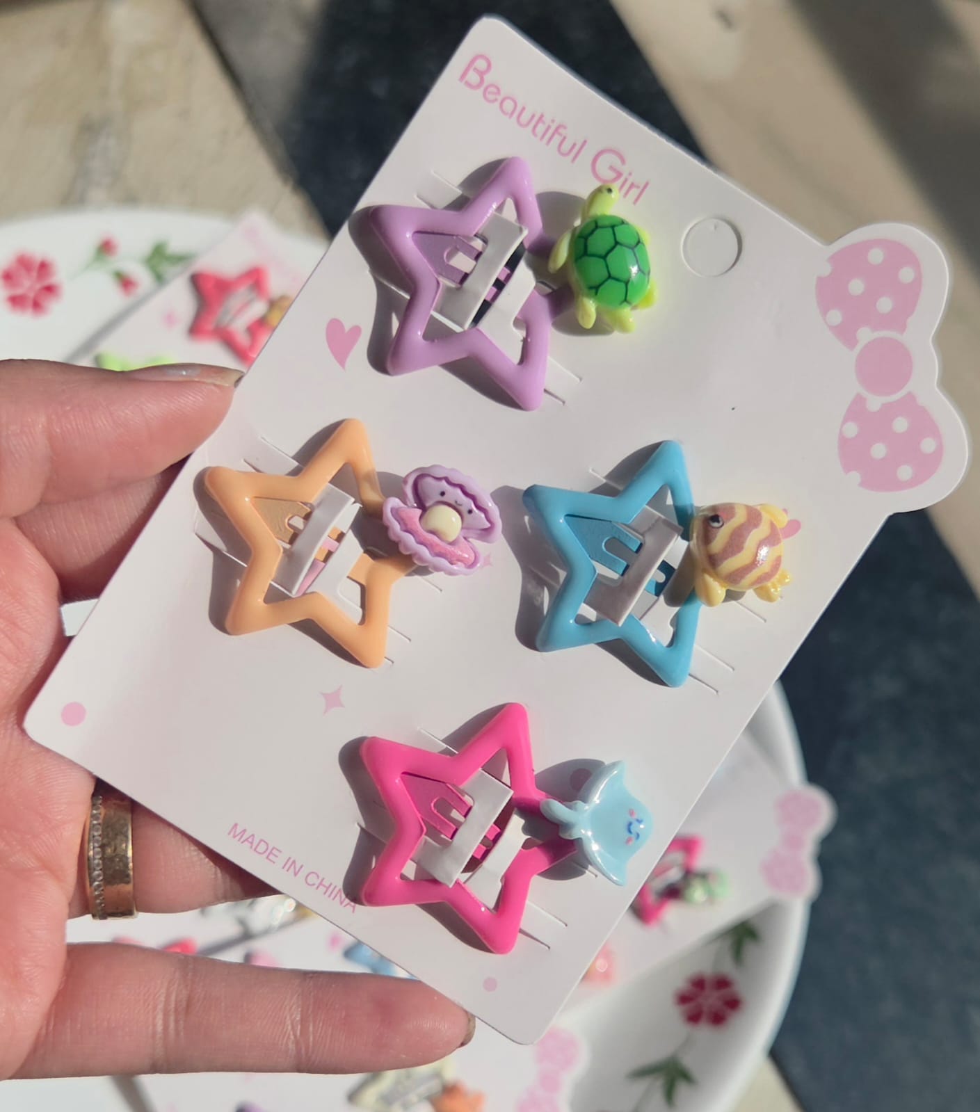 PitilyPops set of four pastel star-shaped snap hair clips for girls featuring cute miniature sea animal charms like a green sea turtle, pink pearl seashell, and blue stingray on a white display card
