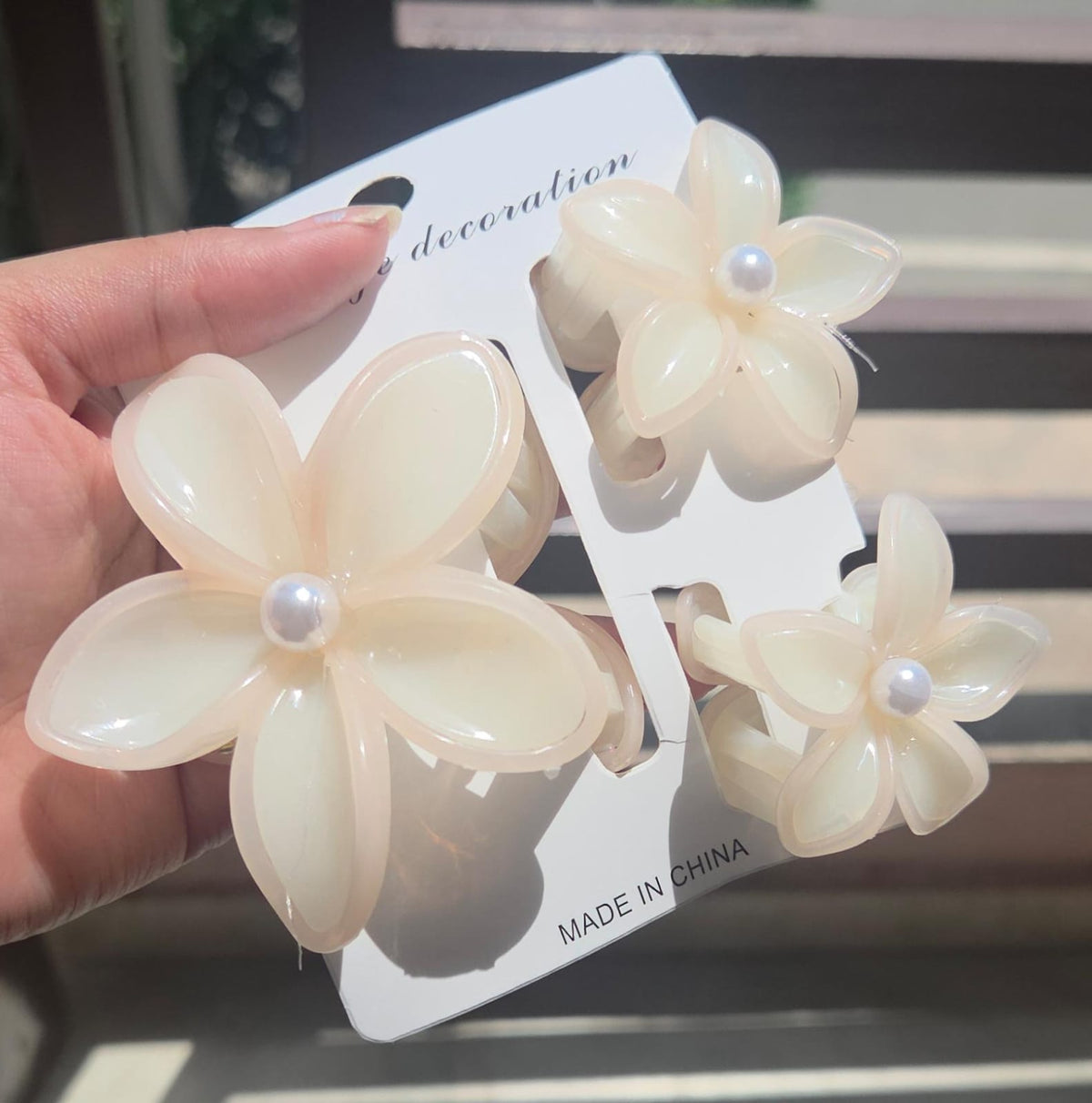 3-piece minimalist flower hair clutcher set including 1 large and 2 small plumeria jaw clips in a soft ivory vanilla cream color with peach highlights.