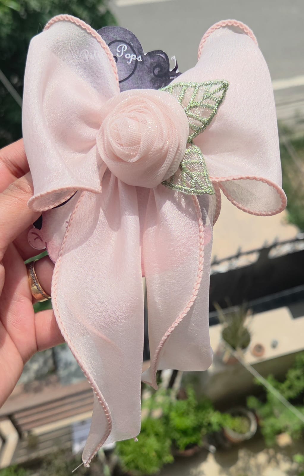 Peach pink chiffon hair bow with a matching fabric rose detail and secure alligator clip.