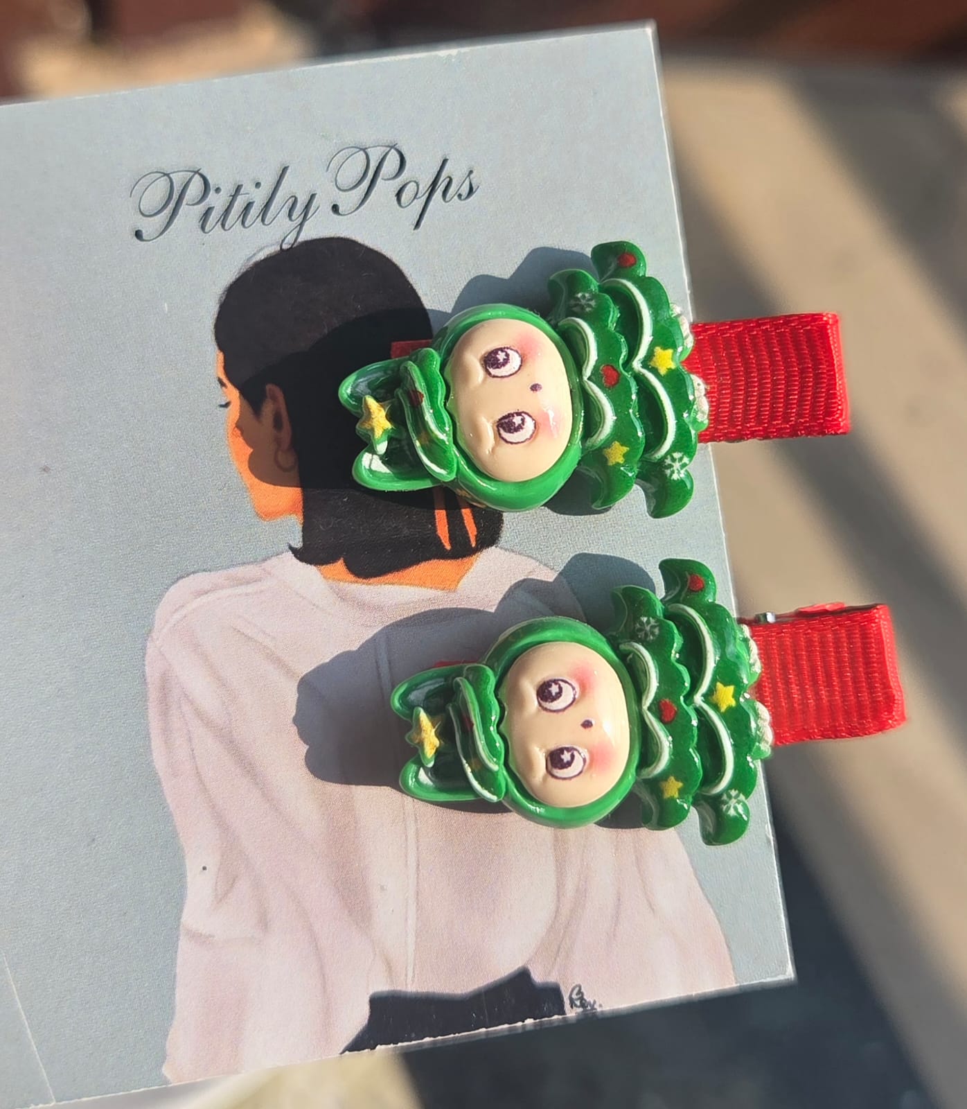 Cute Christmas stocking stuffers for girls featuring handmade-style resin holiday character hair clips on red ribbon-wrapped alligator pins.