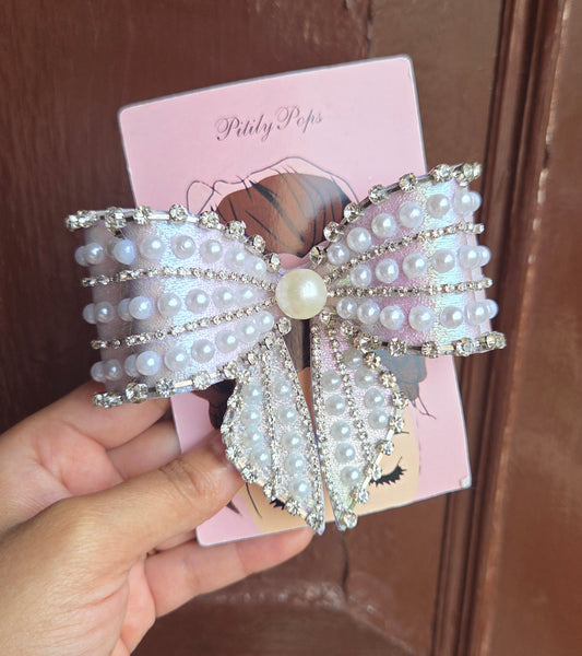Lavender shimmer oversized bow hair clip with pearl and rhinestone embellishments by Pitily Pops, secured with buckle barrette