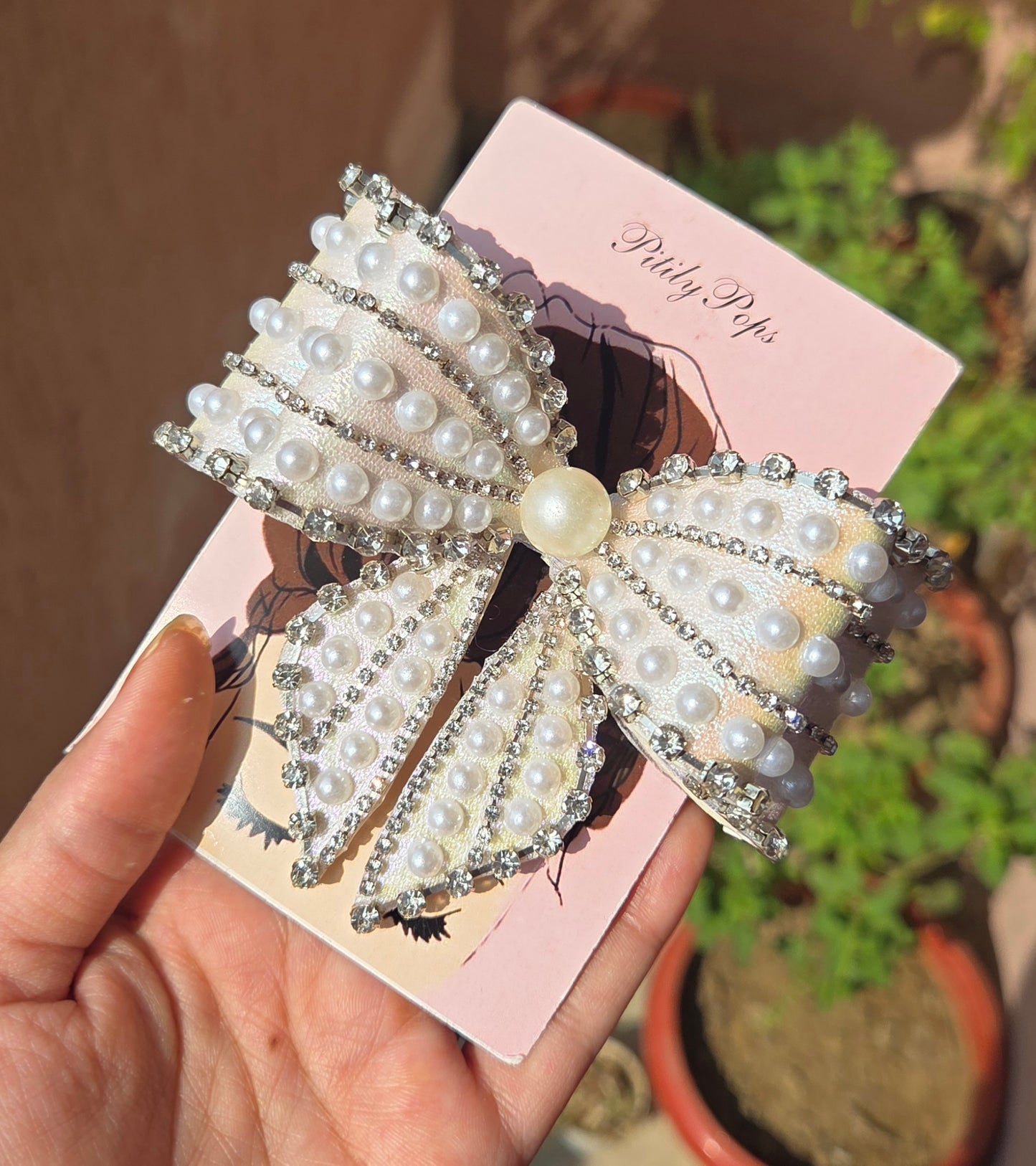 White iridescent pearl and rhinestone embellished oversized bow hair clip with alligator buckle by Pititly Pops