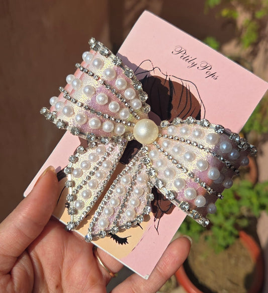 Oversized pink shimmer hair bow clip embellished with faux pearls and rhinestone trim by Pitily Pops