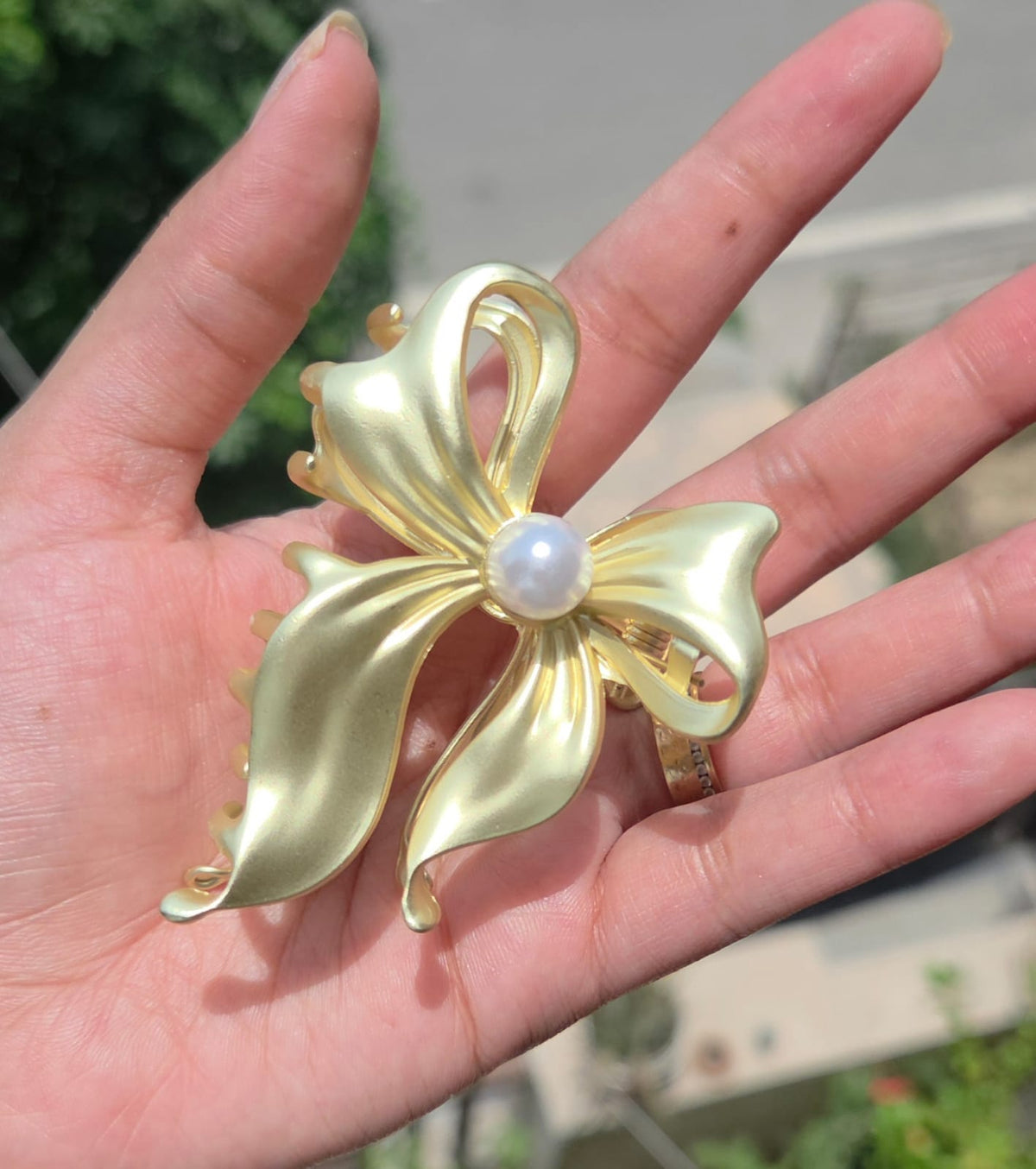Anti-tarnish golden bow metal hair clutcher with a large central pearl detail.