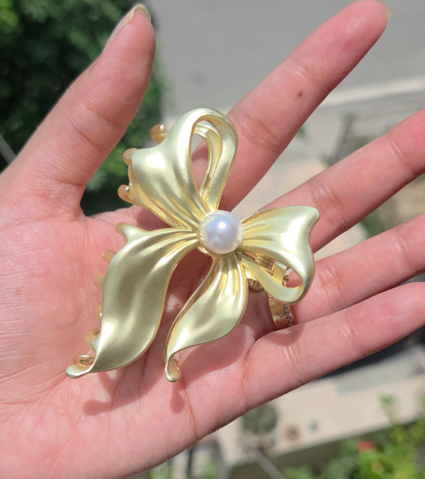 Anti-tarnish golden bow metal hair clutcher with a large central pearl detail.