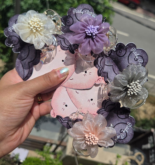 Four pastel organza flower claw clips in white, purple, silver, and pink displayed on illustrated backing cards.