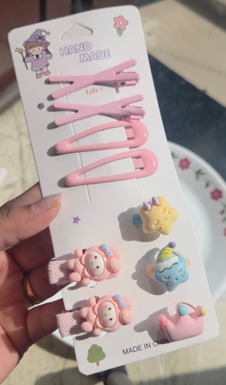 Soft pastel pink hair snap clips set on a handmade display card with star and crown charms.