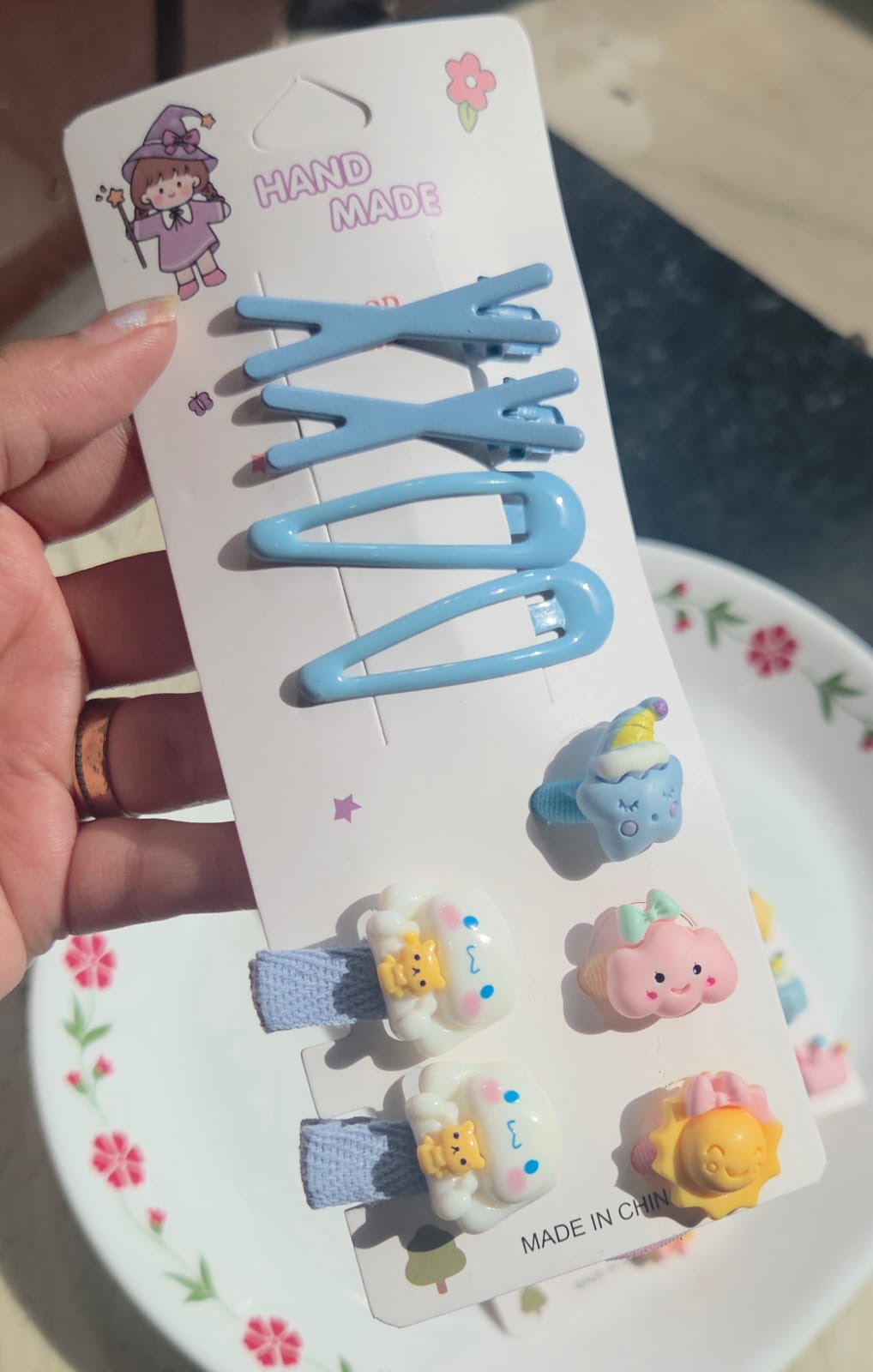 Baby blue snap hair clip card with four handmade clips including blue star and cartoon character charms.