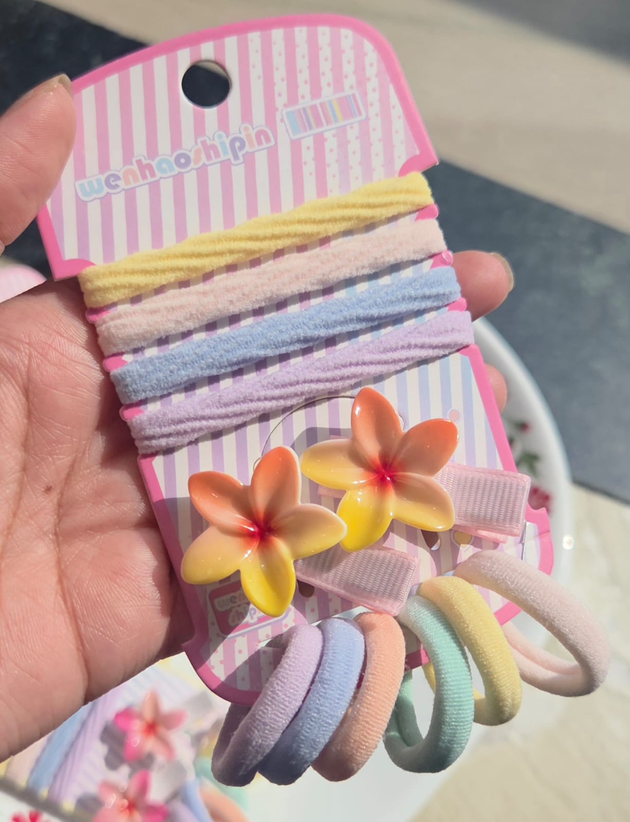 Close-up of the Sunrise Yellow variant hair accessory card featuring two yellow gradient plumeria flower clips and coordinating pastel elastic hair bands