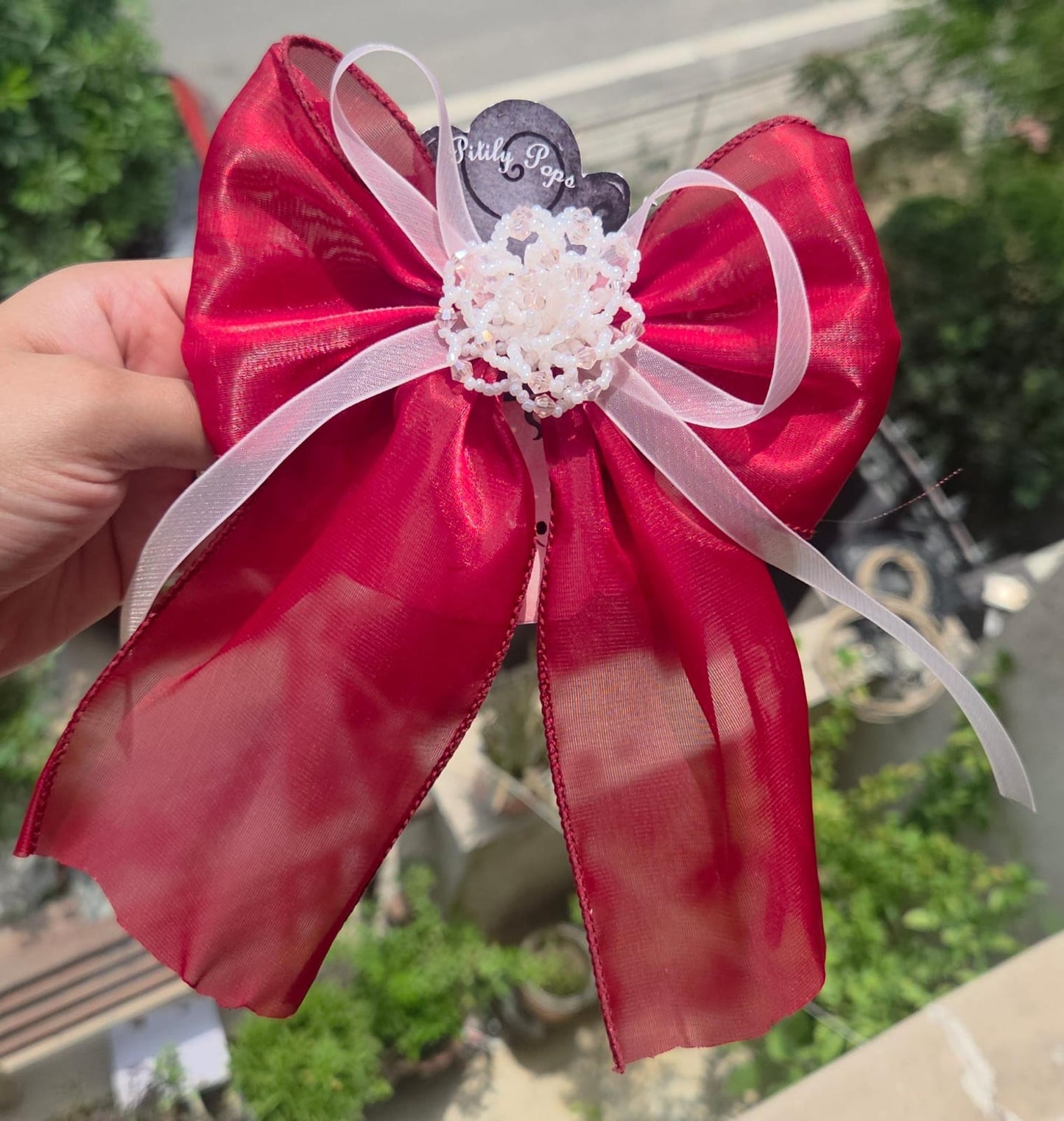 Handcrafted red color flower hair clips showing the delicate, lightweight layered fabric petals.