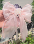 Handcrafted pastel pink flower hair clips showing the delicate, lightweight layered fabric petals.