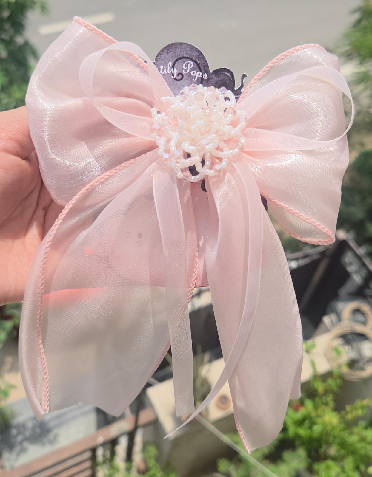 Handcrafted pastel pink flower hair clips showing the delicate, lightweight layered fabric petals.