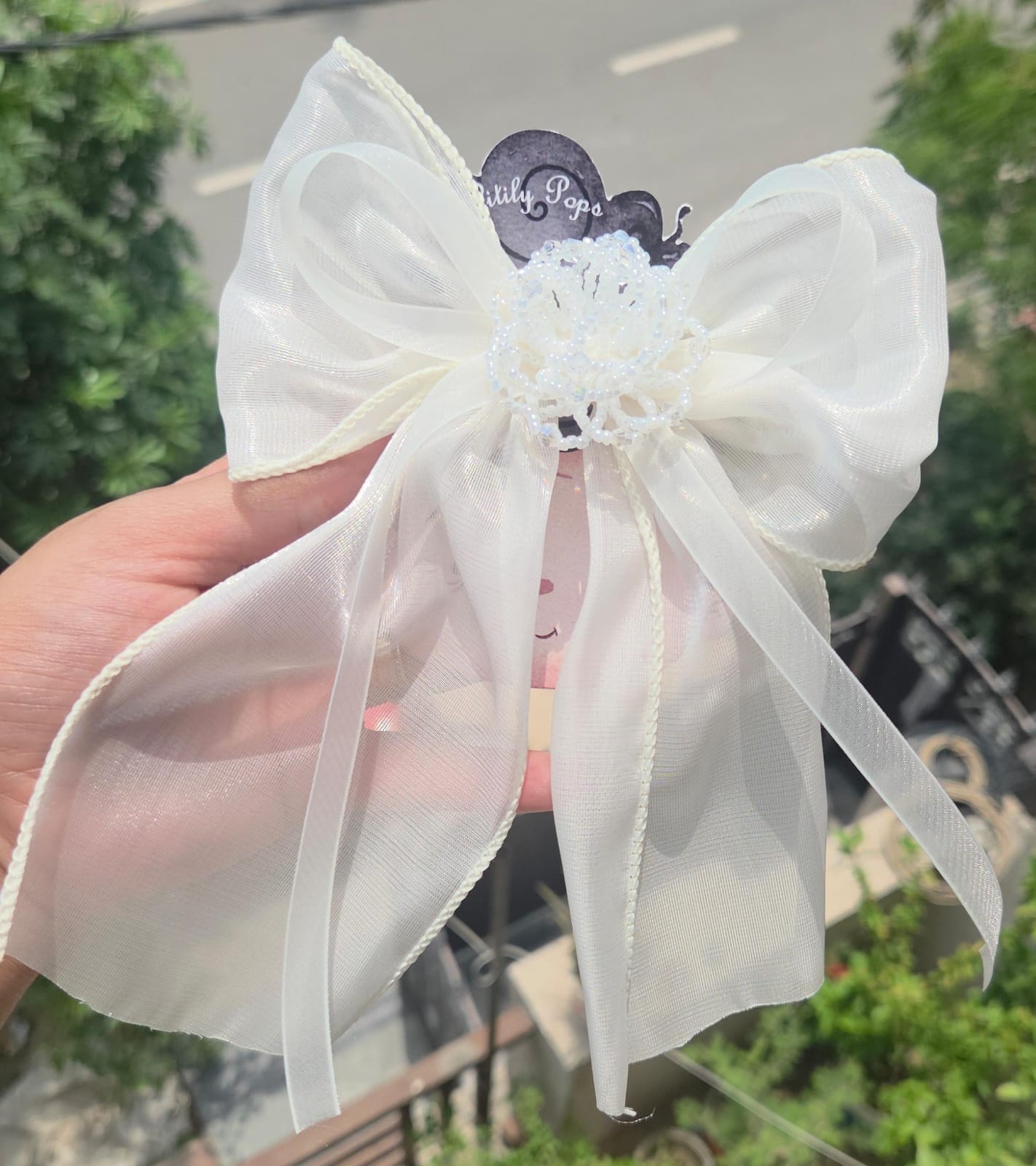 Handcrafted ivory white organza ruffle flower hair clips showing the delicate, lightweight layered fabric petals.