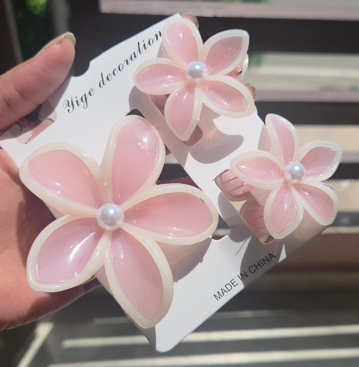 A 3-piece Hawaiian plumeria flower claw clip set containing 1 large and 2 small clutchers in a glossy blossom pink shade