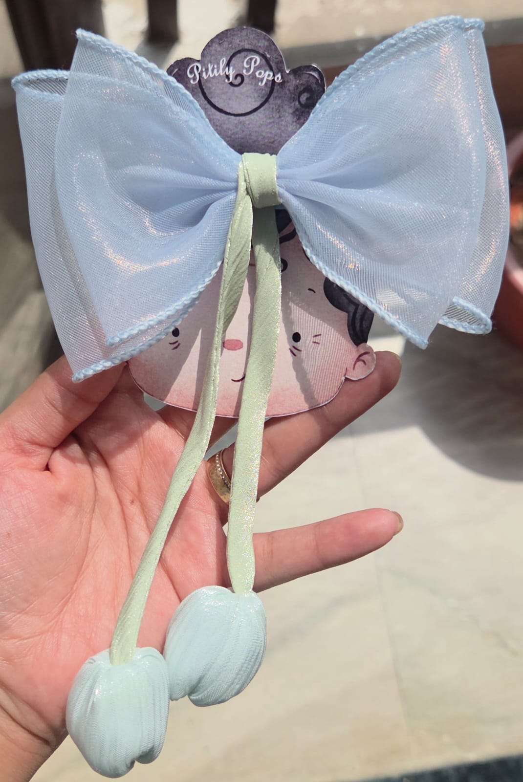 Serene blue sheer organza hair bow with a matching light blue fabric tulip flower accent on a metal alligator clip.
