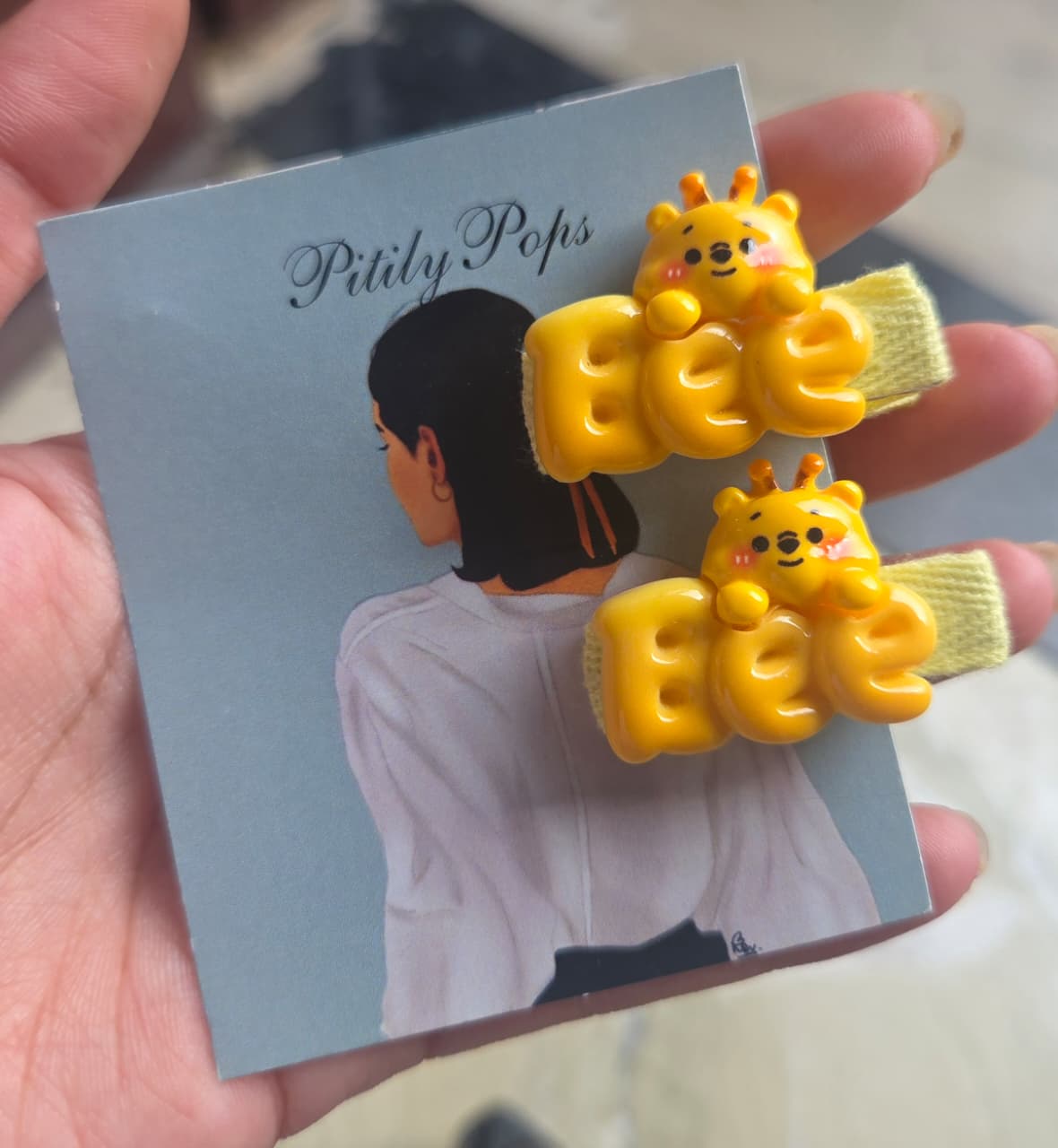 Pair of handmade kids yellow beehive hair clips with tiny white flowers on mint green fabric-wrapped clips