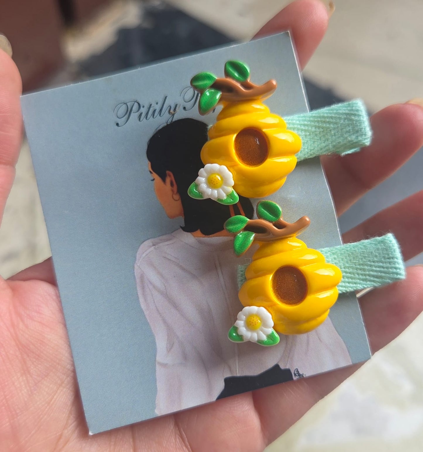 Pair of kids honeycomb and bumblebee hair accessories attached to pink fabric-wrapped clips