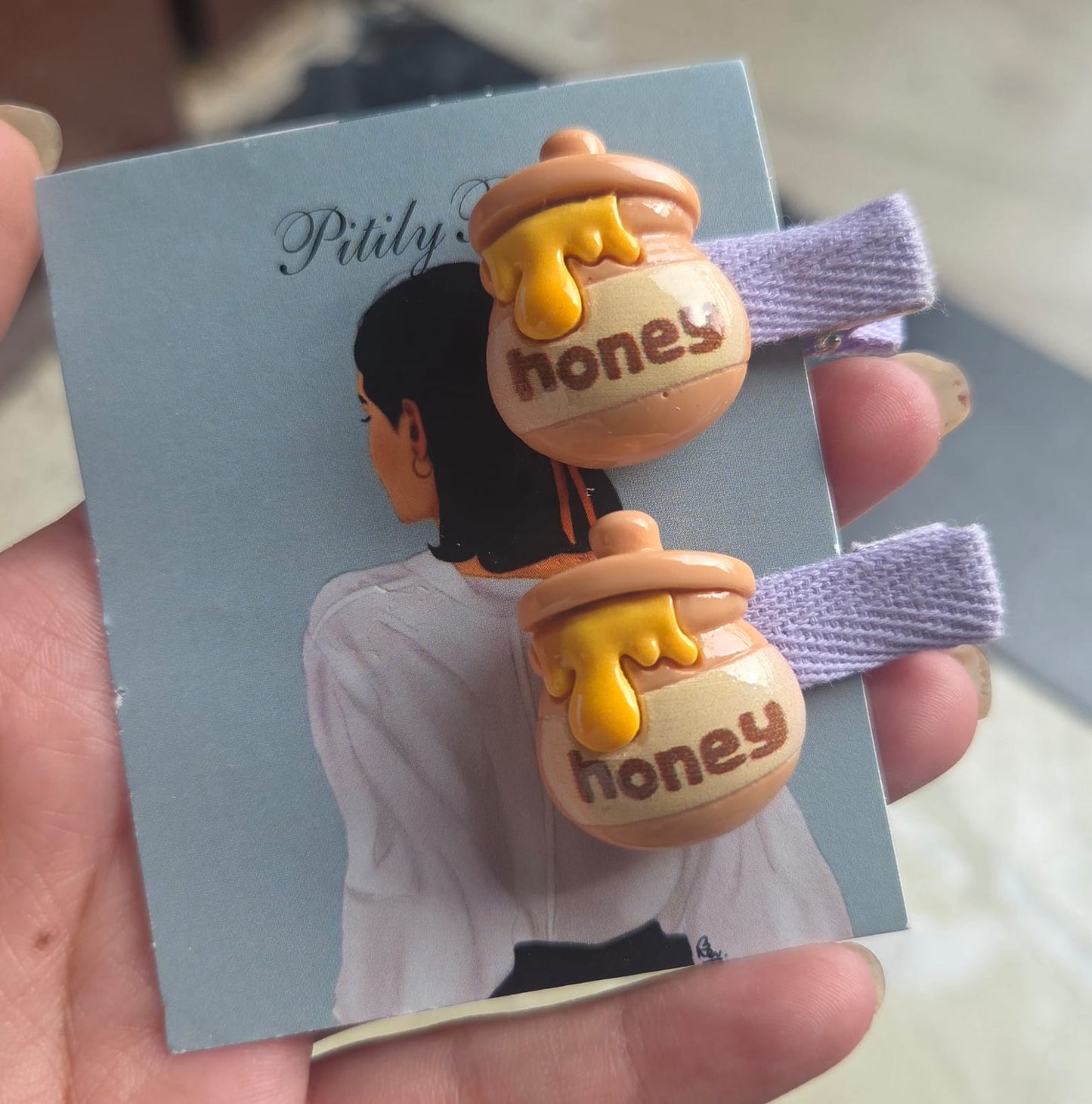 Pair of cute brown honey pot hair clips for girls labeled honey on lavender fabric-wrapped alligator pins
