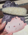 Handcrafted iridescent white crystal hair clip with a rhinestone border by Pitily Pops.
