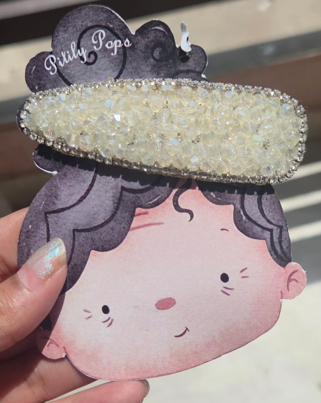 Handcrafted iridescent white crystal hair clip with a rhinestone border by Pitily Pops.

