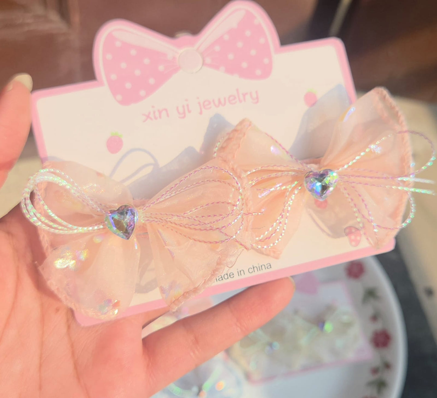 Pair of iridescent light orange organza mesh hair bow alligator clips for kids.