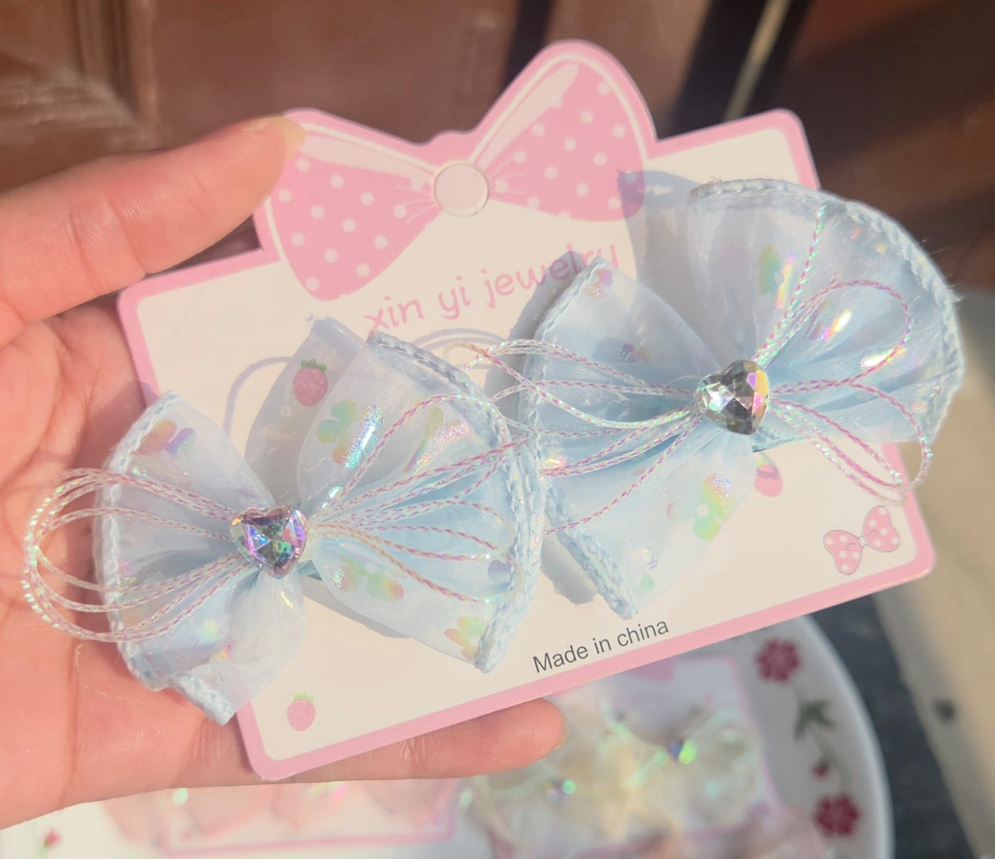 Pair of iridescent light blue organza mesh hair bow alligator clips for kids.