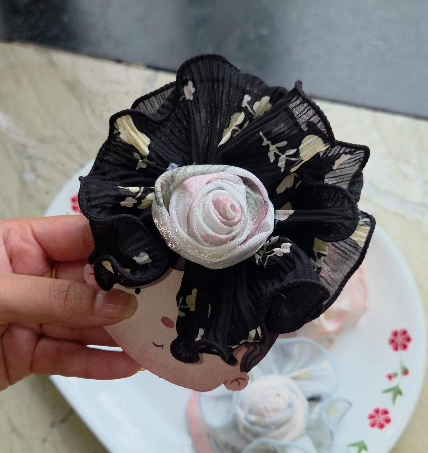 Black floral printed rosette hair clip with secure alligator clip fastener.
