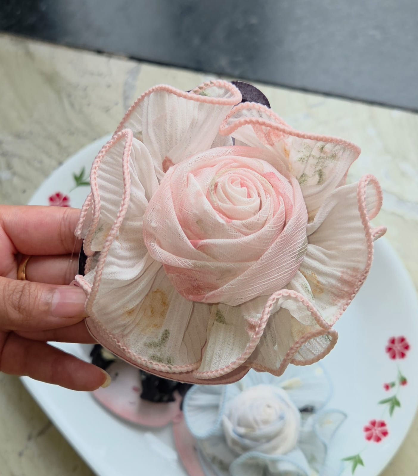 Soft blush pink ruffled fabric rose hair clip with edge stitching on alligator clip backing.