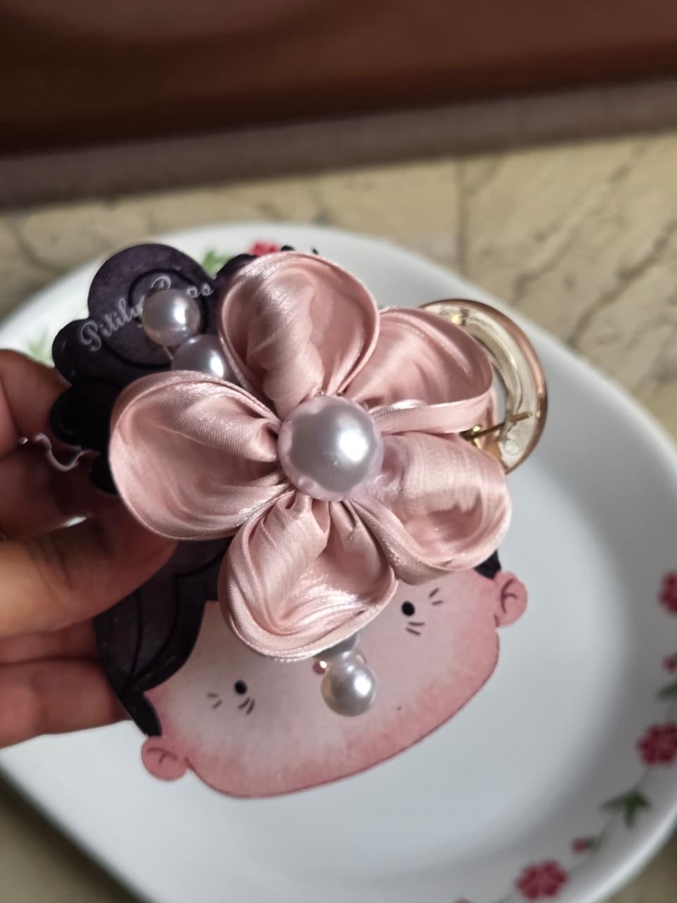    Blush pink satin flower hair claw clip on elegant display packaging.