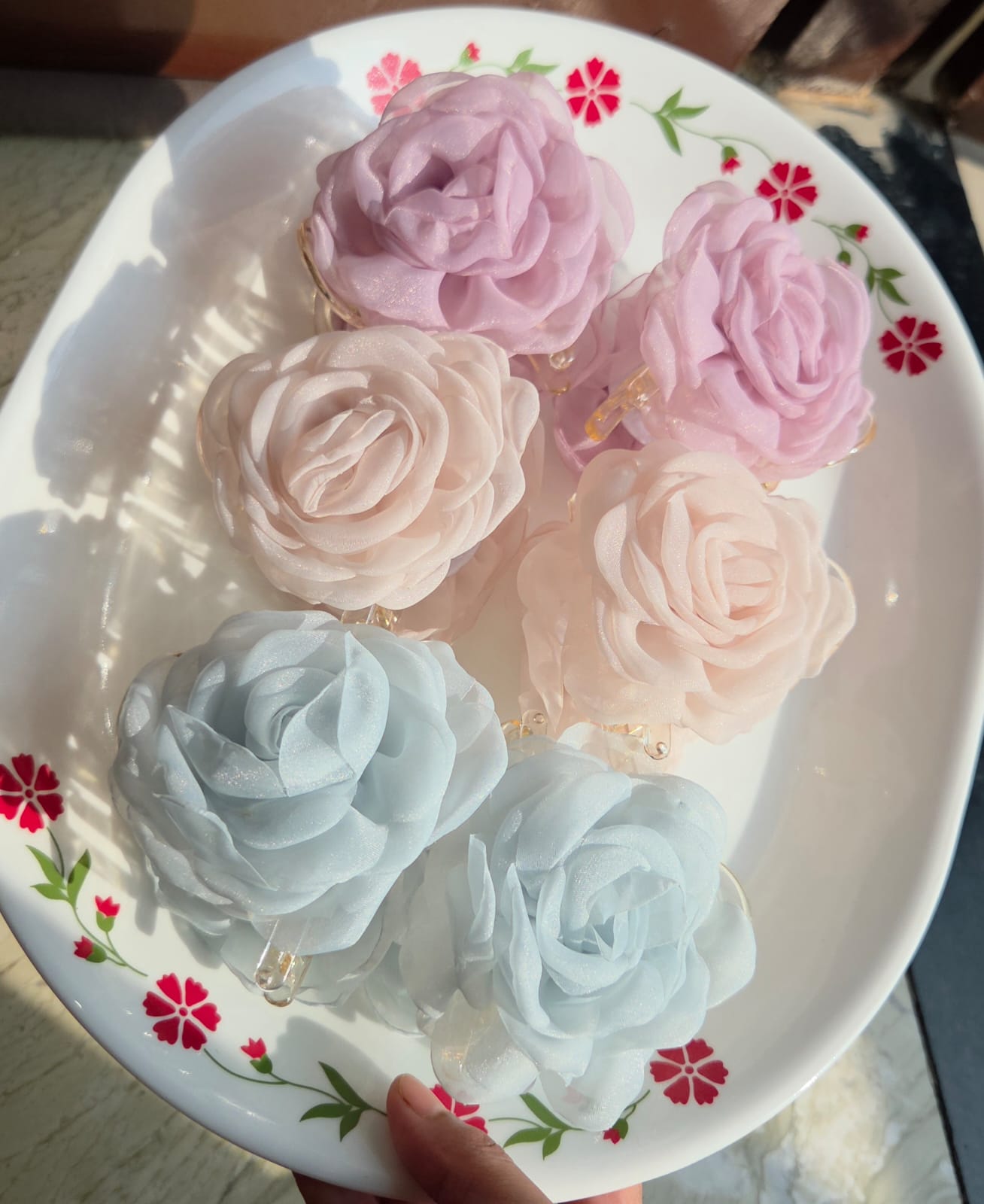    Close up of sheer organza rose petal hair claw clip accessory.
