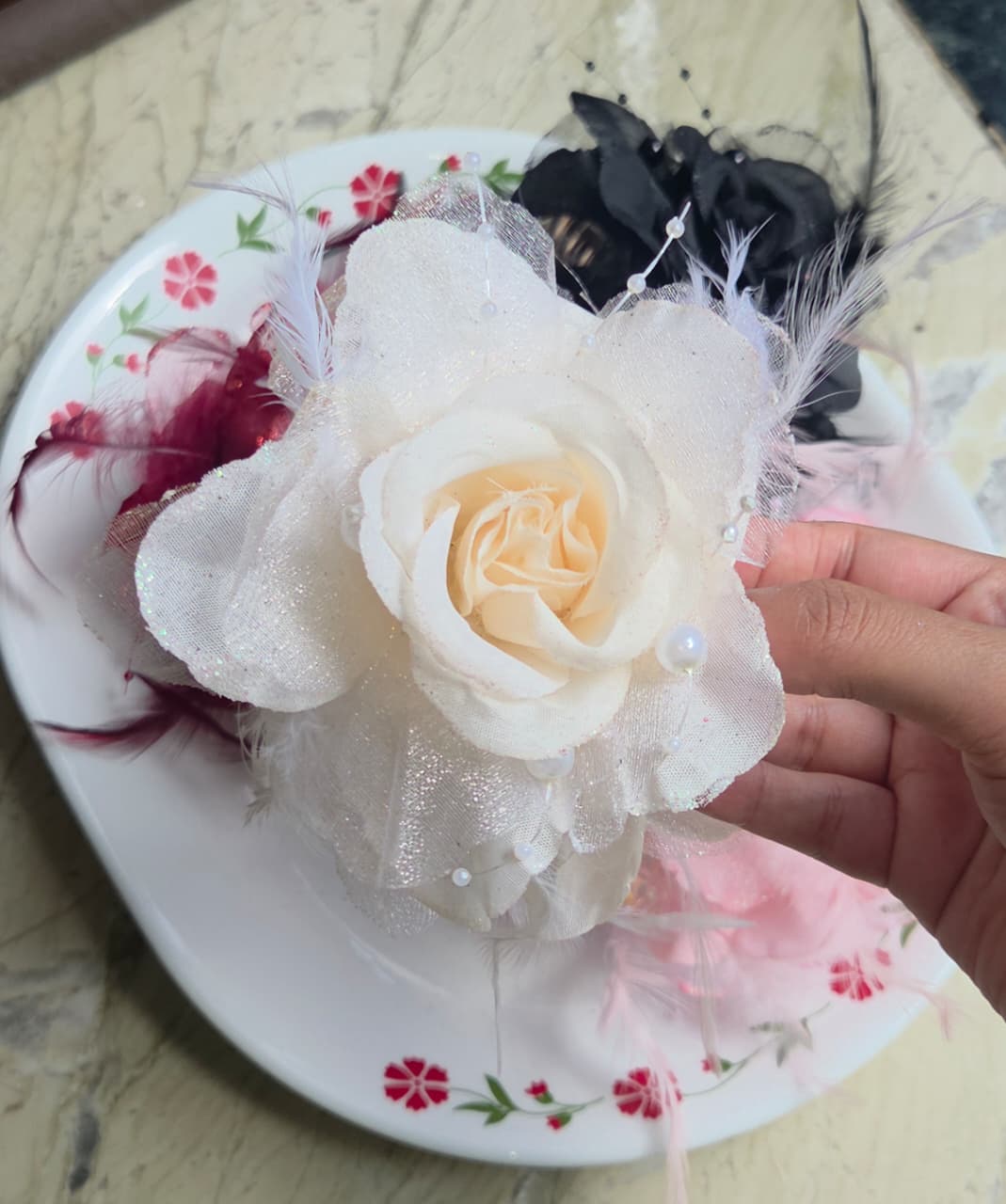    Classic ivory white flower hair clutch with fine feather trim ideal for bridal and formal hairstyles.