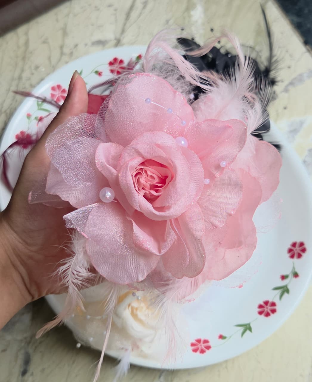    Feminine soft pink fabric rose hair clutch clip featuring light pink feathers and pearl sprays.

