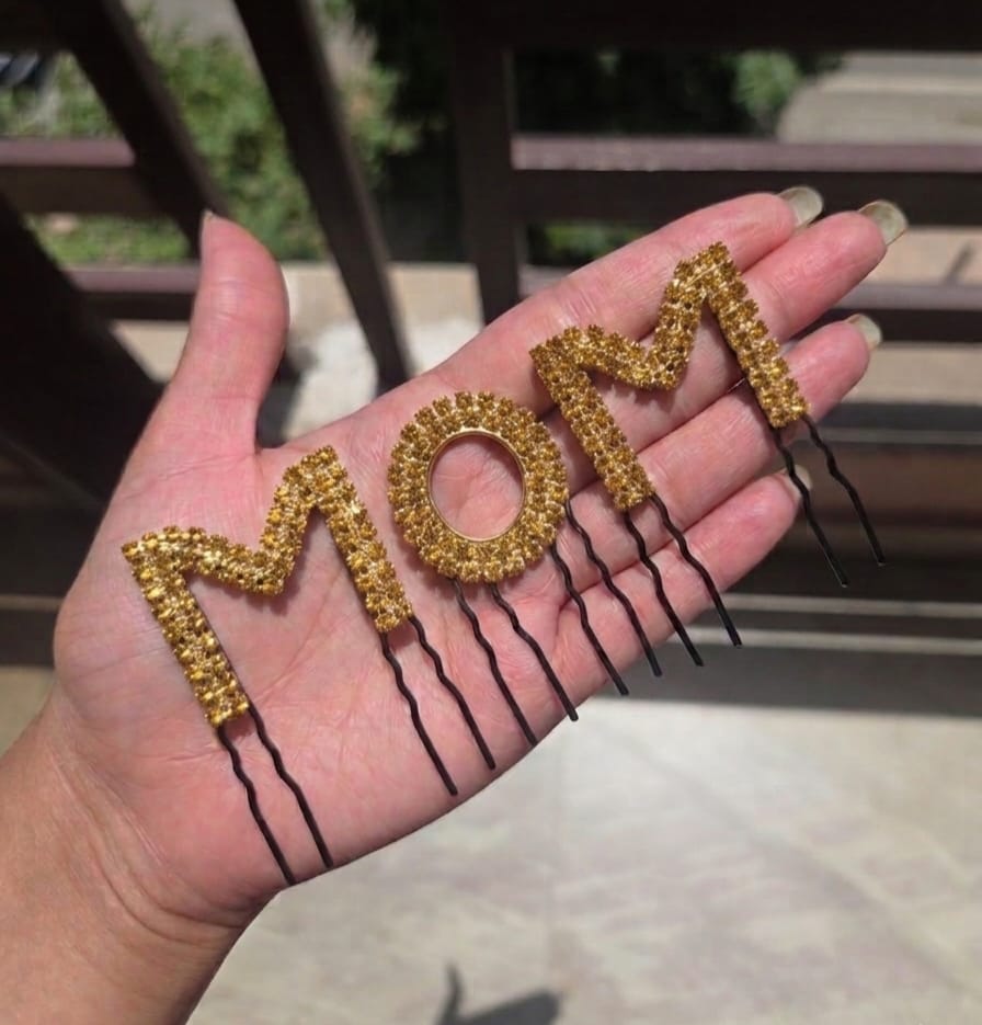 Gold rhinestone MOM hair comb pin held in palm – sparkly baby shower hair accessory
