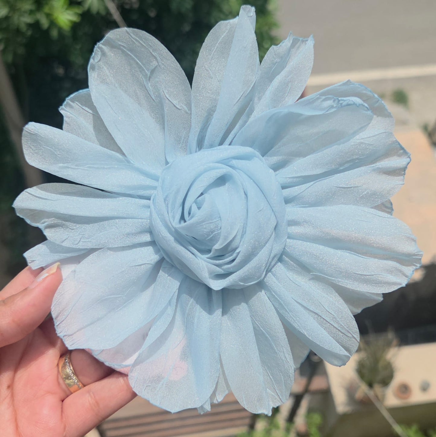    Light sky blue oversized flower hair clip made of airy chiffon fabric for romantic hairstyles.
