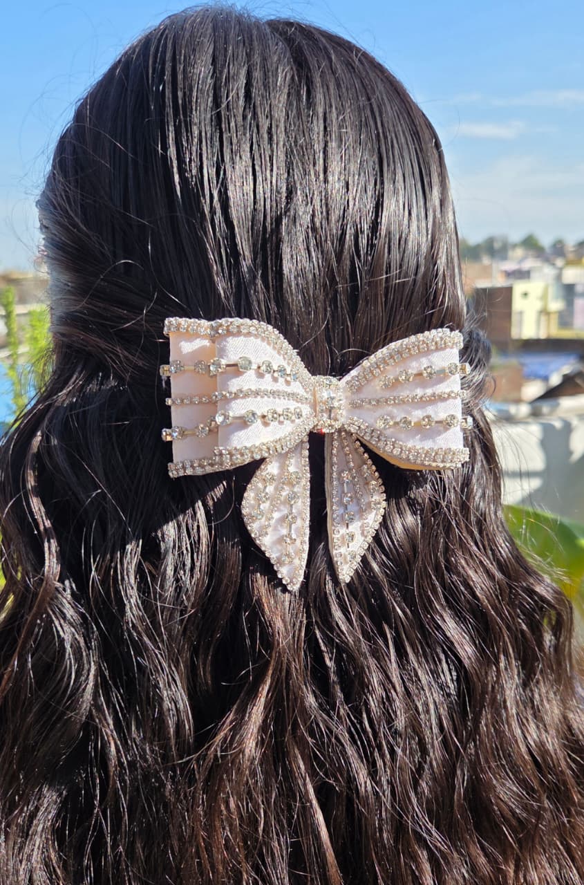 Premium sparkling rhinestone-studded white bow hair accessory with a secure buckle back closure.