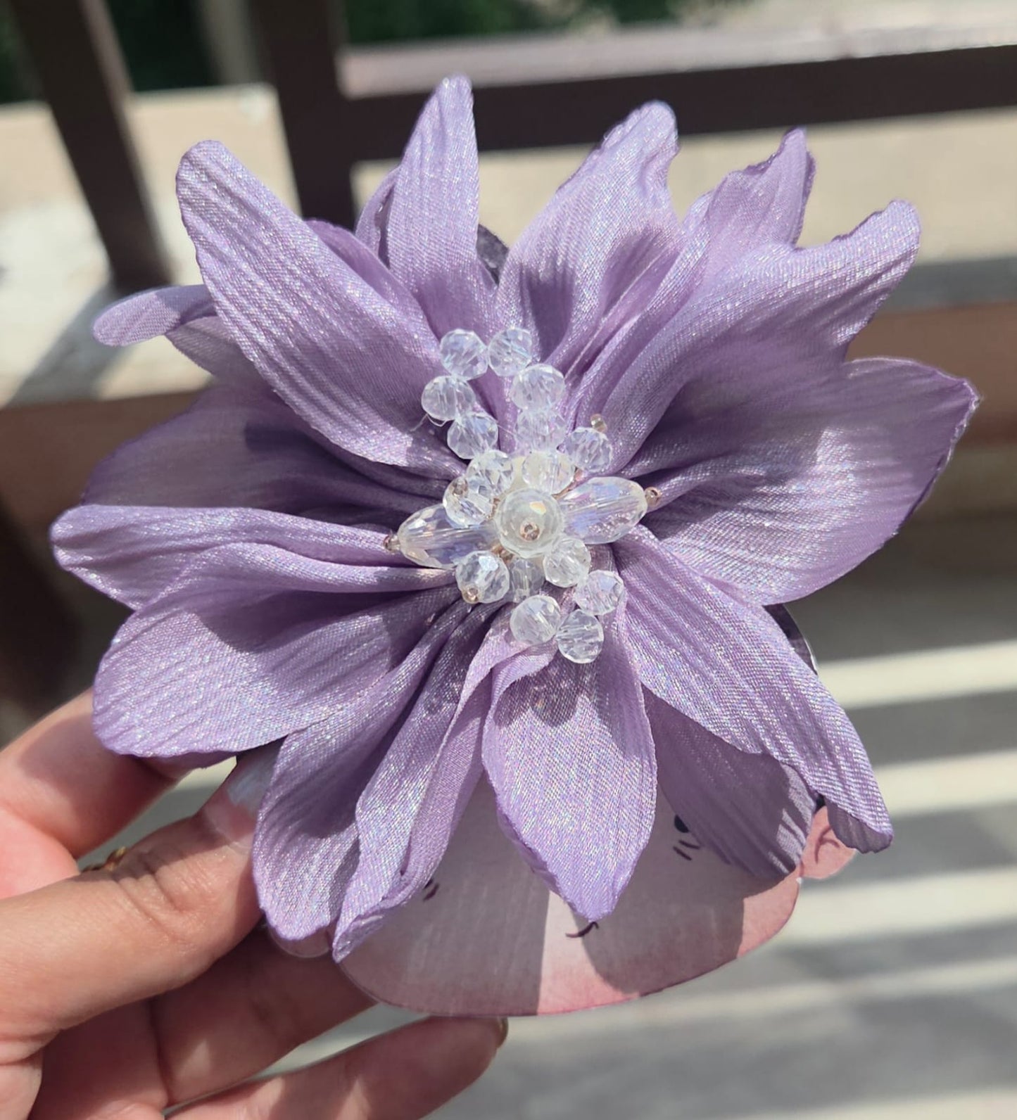 Pastel lavender purple blooming floral hair clip with clear bead accents, mounted on a metal alligator backing.