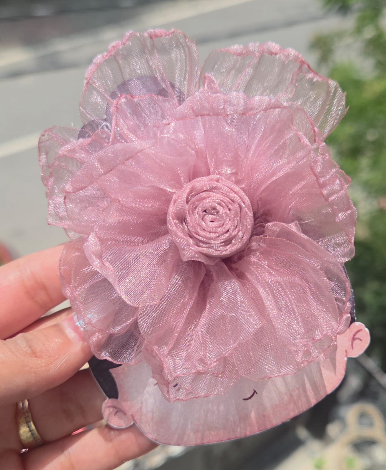 Close-up of handmade chiffon rose hair accessories featuring ruffled layered petals and hidden alligator clips on the back.