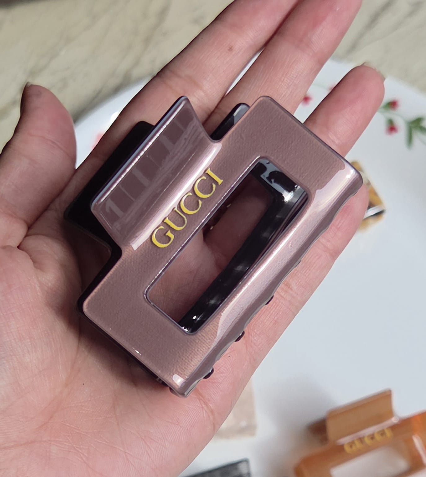    > "Dusty plum mauve glossy finish rectangular hair jaw clip with gold letter detailing."
