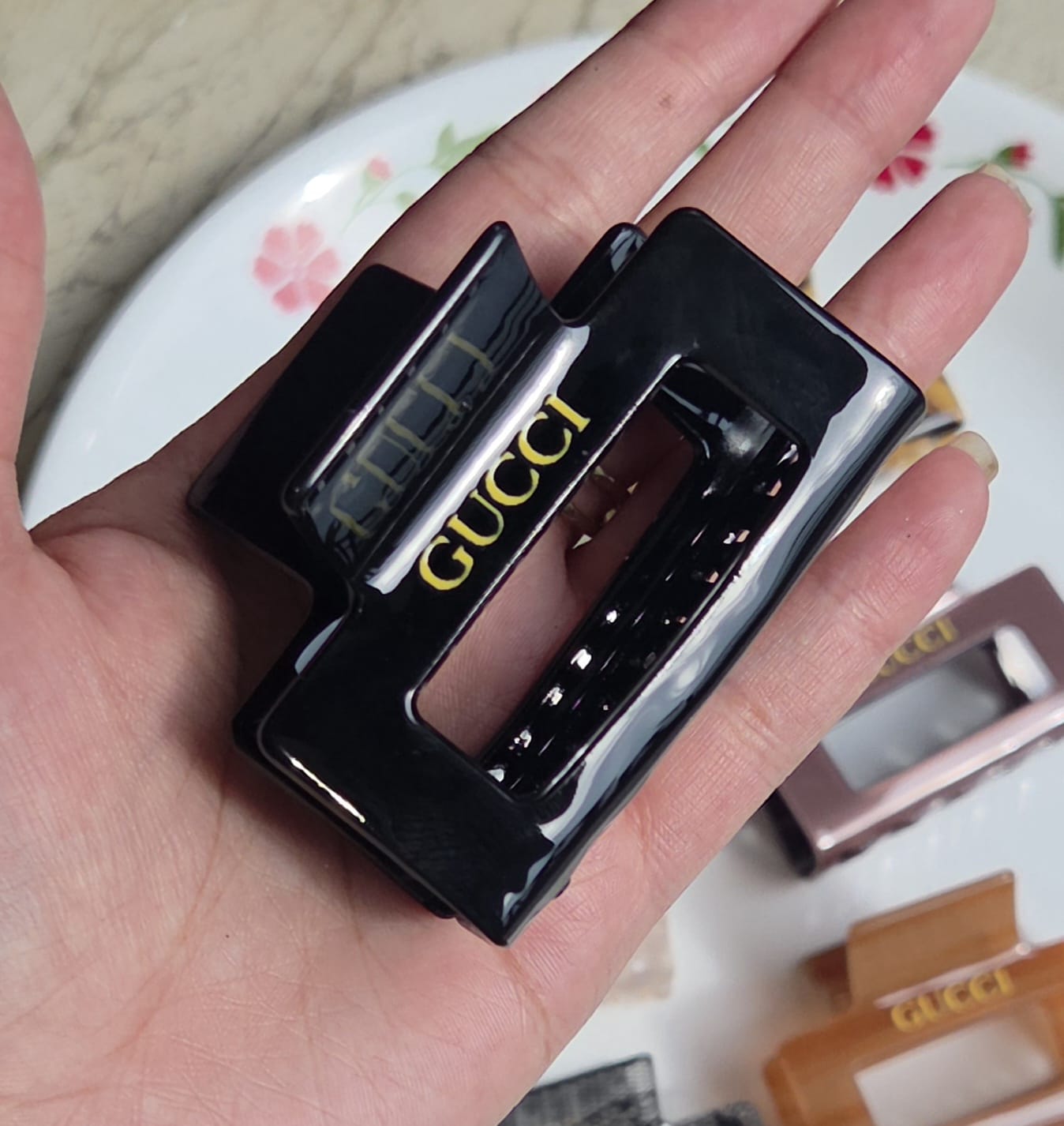    > "Sleek glossy black acrylic medium rectangular hair clutcher clip for thick hair."
