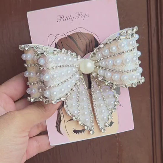 Handcrafted white iridescent bow barrette with rows of faux pearls rhinestone chain trim and large center pearl for bridal wedding hair